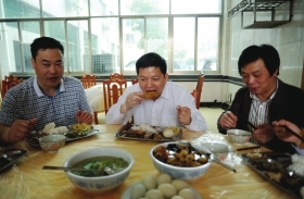 4月17日，湖南省畜牧水产局局长袁延文(中)带头吃鸡肉，他希望能消除许多人对鸡肉的恐惧。　图/记者辜鹏博