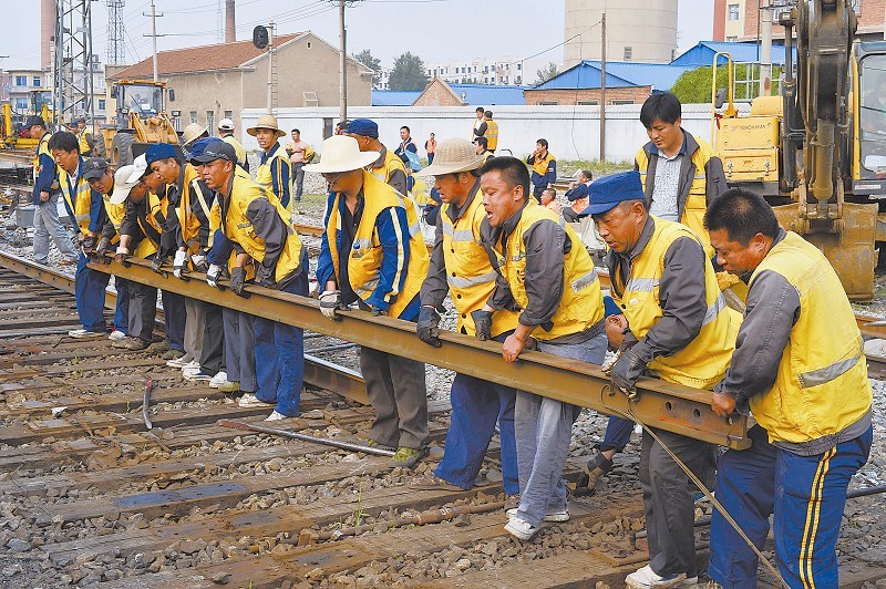四平工务段职工正在将旧钢轨抬出线路