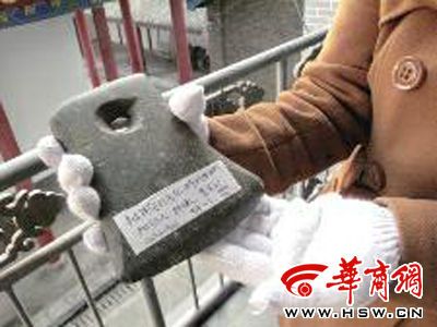洛南县博物馆工作人员向华商报记者展示村民上交的石斧 实习记者 白鹏飞 摄