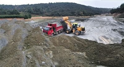 12月11日，挖掘机将灰渣装上运输车。在陬市镇和架桥镇间堆积着上百亩由火电厂产生的煤渣和灰渣。