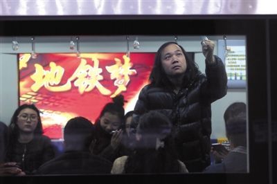 建国门站，乘客在地铁上。当天是北京地铁票价2元时代的最后一天。
