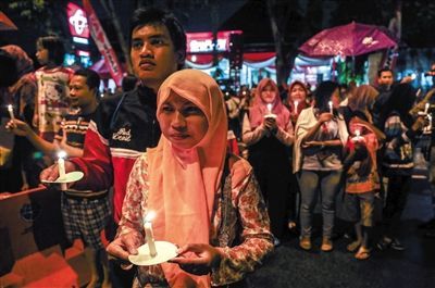 2014年12月31日，印尼泗水，民众点烛为亚航失事客机遇难乘客祈福。亚航空难，令廉价航空安全受到质疑。