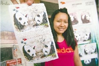 2月25日，在馬來西亞首都吉隆坡，一名集郵愛好者展示購買到的大熊貓郵票小全張。 