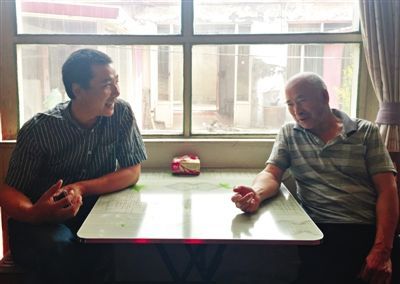 昨日午饭后，李万良和王瑞全父子坐在客厅唠嗑。新京报记者 李相蓉 摄