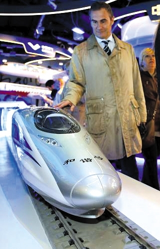日前，在意大利米兰世博会中国企业联合馆，一名参观者观看中国南车生产的“和谐号”动车组模型。