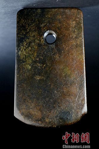 新石器时代玉斧，为史前重要文物，其光泽度、雕琢方法、圆孔对钻等均与台北故宫及大陆国博馆藏一级文物极相似。