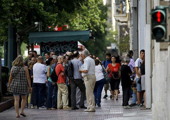 希臘民眾在街頭ATM機前排長隊取現金。