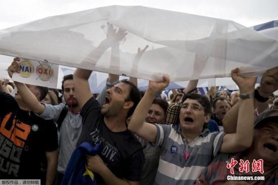  希腊危机风波持续，图为游行群众高举标语，希望希腊继续留在欧元区。 