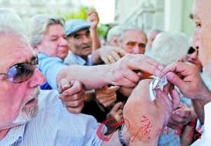 6日，希臘雅典，希臘退休人員在銀行外排隊等待領取養老金。