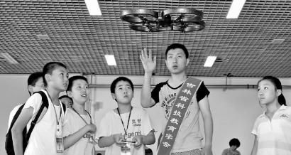 李梓涵(右二)指导小学生们操控无人机 新文化记者 吴廷 摄 