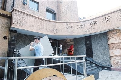 7月23日，已經關門停業的湘鄂情創始門店定慧寺店，工作人員正在將桌椅搬出。