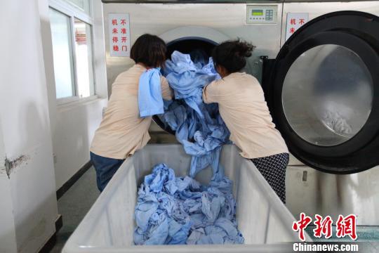 高溫下的廣州鐵路洗衣工：一天清洗列車臥具四萬件