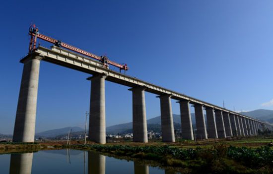 目前泛亞鐵路西線雲南境內段建設正全面加速推進。圖為施工人員在其中一特大橋上進行架梁。中新社