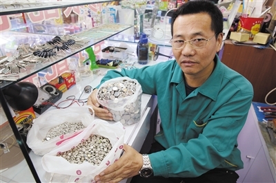 修表師傅明文友為三年來收集的上萬粒廢紐扣電池無法處理而發愁。