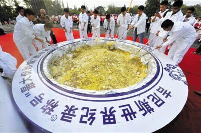 2015年10月22日，江苏省扬州市，一些学生在同时挥勺翻炒“最大份炒饭”。