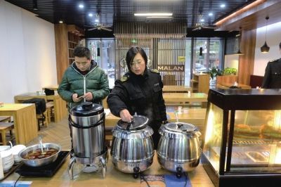 执法人员在餐厅检查食品安全。京华时报记者王海欣摄