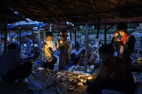 曼德勒，缅甸商人在市场上检查玉器。资料图片