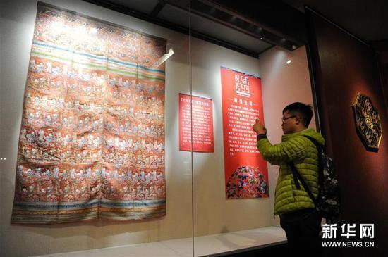 12月31日，市民在一件“蜀锦被面”刺绣展品前拍照。