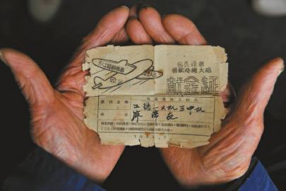 廖弟友保存著自己1951年第一次捐款的證明：抗美援朝捐獻飛機大炮獻金證。