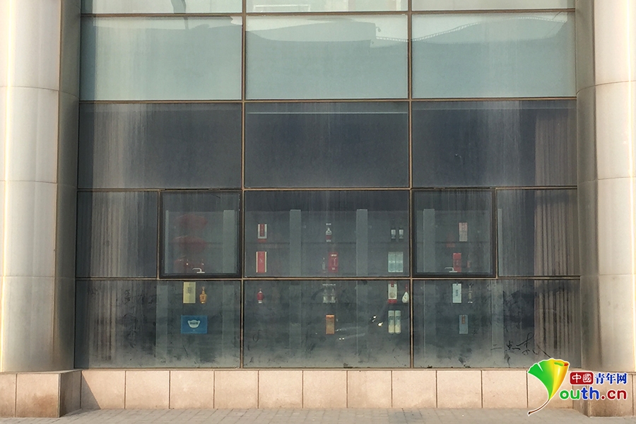 在大厦正面，一楼的展示柜中仍然摆放着酒品。中国青年网记者 杜美辰 摄