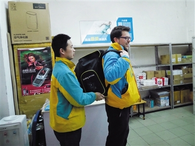 2月1日，慈云寺，来自英国的弗兰克（右）背上装有快递货物的背包，体验快递员工作。 本组图片/新京报记者 王嘉宁 摄