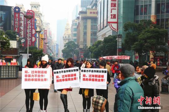 资料图：2015年2月4日，几位女青年手举标语出现在上海闹市区，无声地抗议亲友的逼婚行为，其标语上写着“妈，过年回家别逼婚。我的幸福我主宰！”中新社发 章渝 摄 图片来源：CNSPHOTO