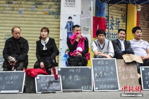 资料图：2015年3月17日，广州海珠区康乐村，小制衣厂的老板和管理人员拿着简易的招工牌在路边招工。中新社发 陈骥旻 摄