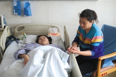 昨日，武警总医院，家人在病床前照顾刚做完肝脏捐献手术的妹妹。新京报记者 周岗峰 摄
