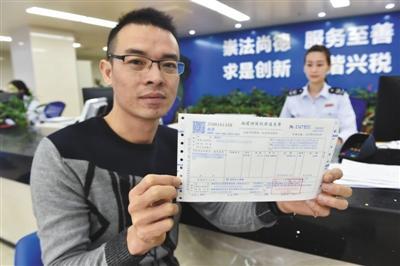 1日，在福州地税综合办税中心办税服务厅，福州市民郑先生在展示领到的福建省首张二手房交易增值税发票。