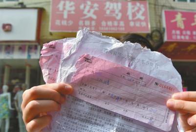 11日，受骗学员向记者出示“四川省华安驾校学车合同书”和收据。