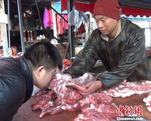 资料图：一位卖羊肉的摊贩正在教顾客从肉质、色泽、气味等方面识别瘦肉精羊肉 阚力 摄