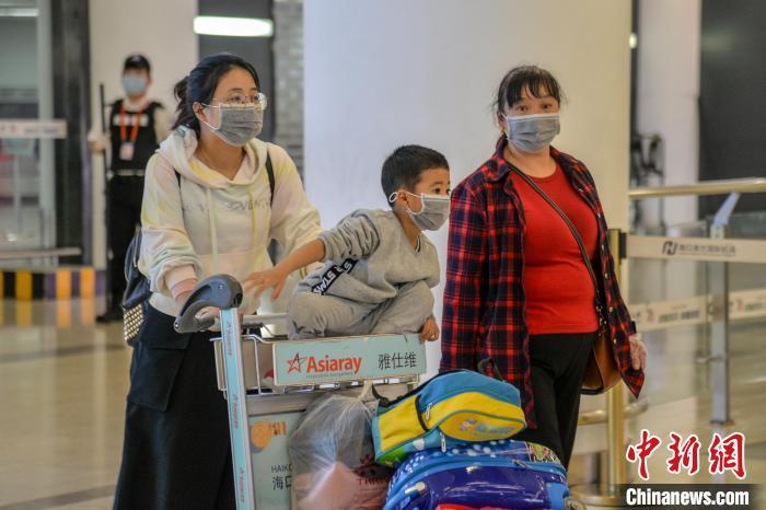 图为戴着口罩的旅客抵达海口美兰国际机场。　洪坚鹏 摄