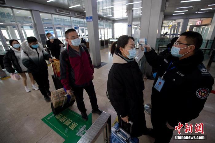 1月27日，山西太原站，工作人员为进站旅客测量体温。2021年中国春运即将开启，各地在疫情防控常态化下，鼓励民众减少出行。 中新社记者 韦亮 摄