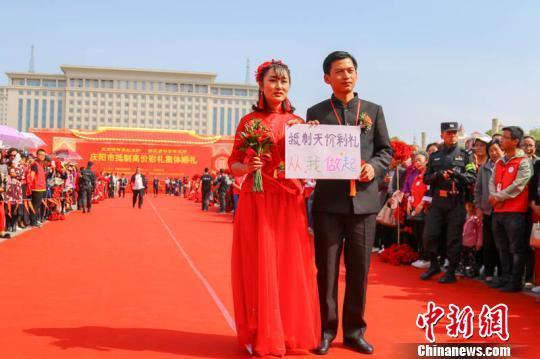 资料图： 2018年5月4日，甘肃庆阳市举办了“移风易俗青年先行”集体婚礼，54对新人参加婚礼并承诺“抵制天价彩礼，从我做起”。 陈飞 摄
