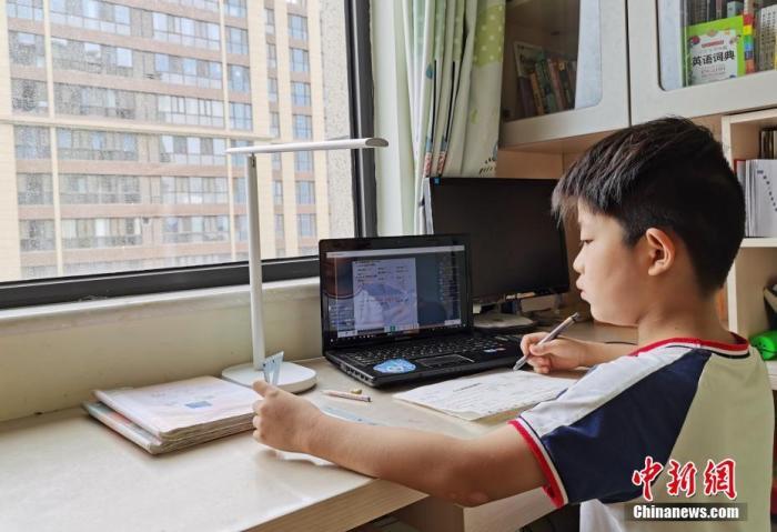 一小学生在家中通过平板电脑收看直播上数学课。(资料图片)中新社记者 翟羽佳 摄