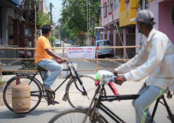 5月15日，人们骑车经过印度阿加尔塔拉一处隔离区。新华社图。 